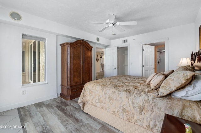 bedroom with light wood-style floors, baseboards, visible vents, and a ceiling fan