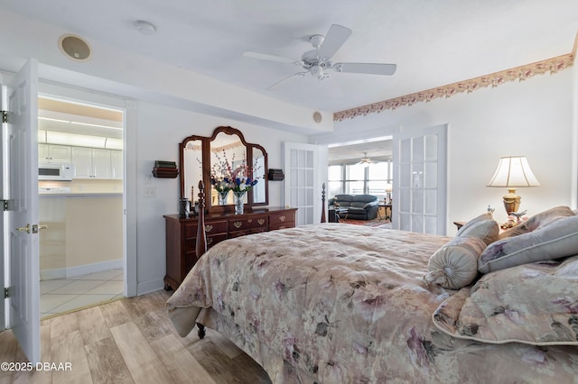 bedroom featuring light wood-style flooring, baseboards, and a ceiling fan