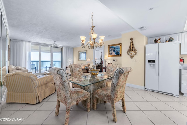 dining area with light tile patterned flooring, visible vents, baseboards, and ceiling fan with notable chandelier