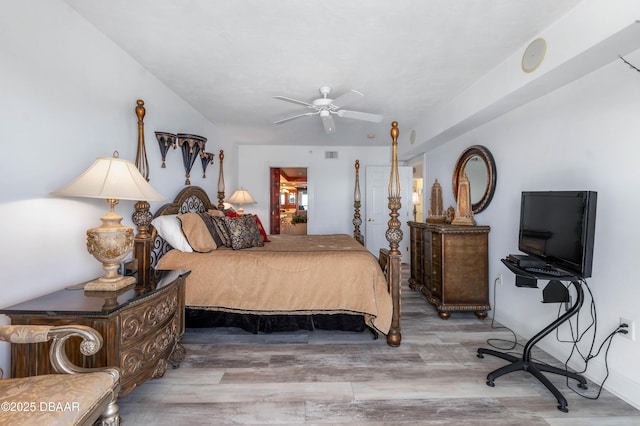 bedroom featuring ceiling fan, wood finished floors, visible vents, and baseboards