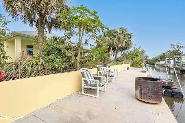 view of patio featuring a water view and a dock