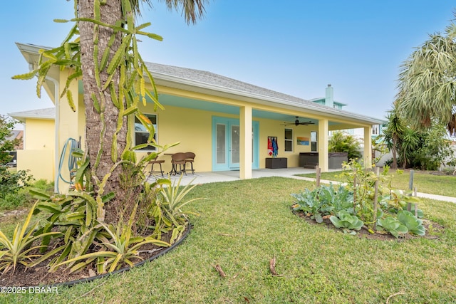 rear view of house featuring a yard, french doors, ceiling fan, a patio area, and an outdoor hangout area