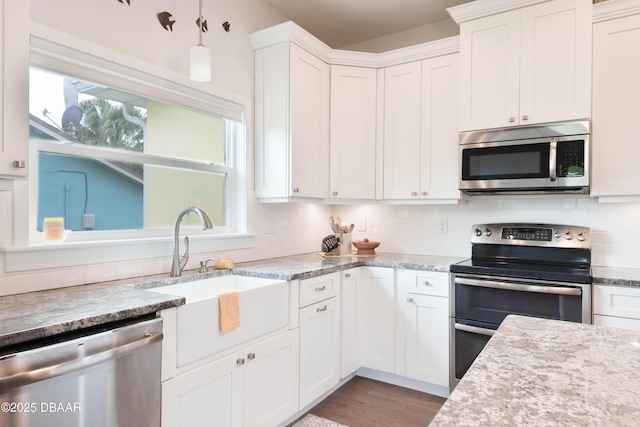 kitchen with sink, white cabinets, stainless steel appliances, and decorative backsplash