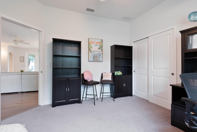 carpeted office with ceiling fan