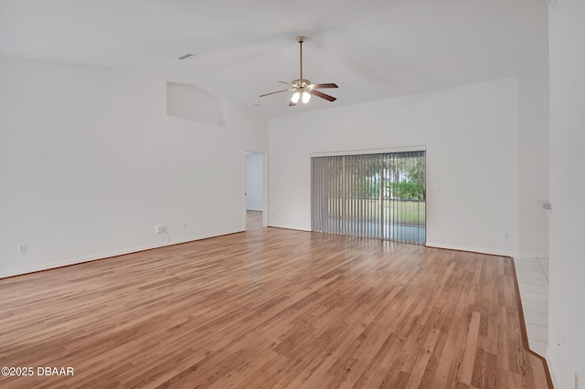 empty room with a ceiling fan, light wood finished floors, and high vaulted ceiling