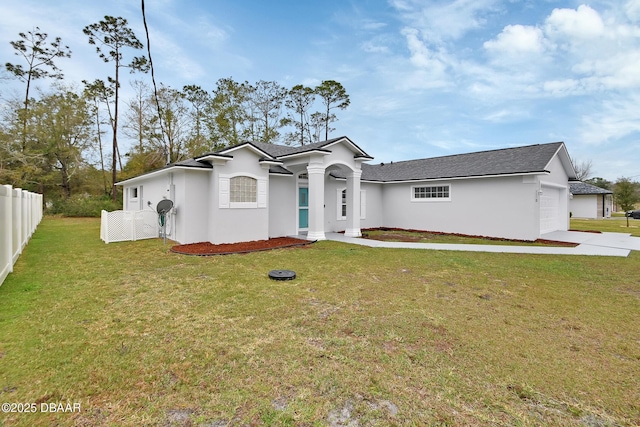 view of front of house with a front yard, an attached garage, fence, and stucco siding