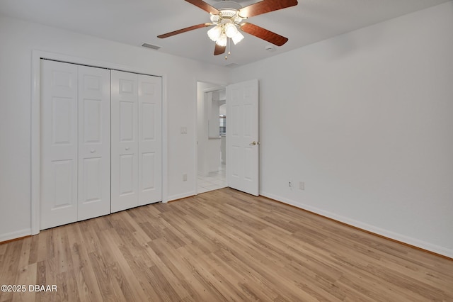 unfurnished bedroom featuring baseboards, visible vents, ceiling fan, a closet, and light wood-type flooring