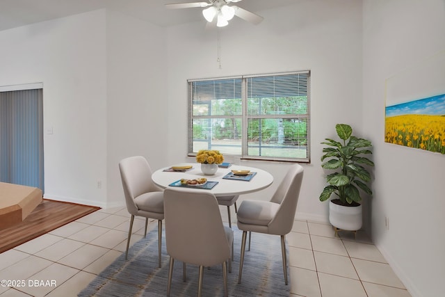 dining area featuring baseboards, a ceiling fan, and tile patterned flooring