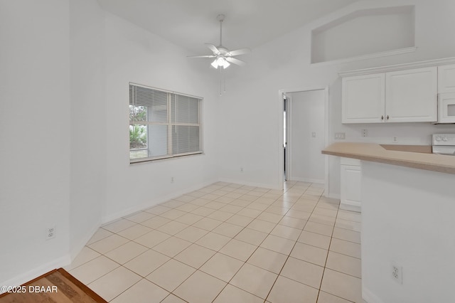 unfurnished dining area featuring light tile patterned floors, high vaulted ceiling, baseboards, and ceiling fan