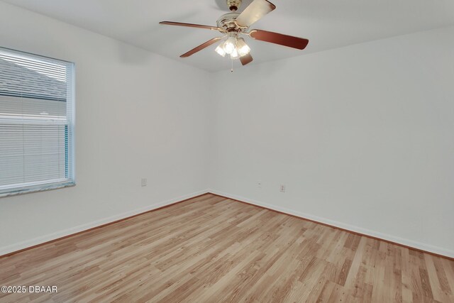 unfurnished room featuring a ceiling fan, wood finished floors, and baseboards