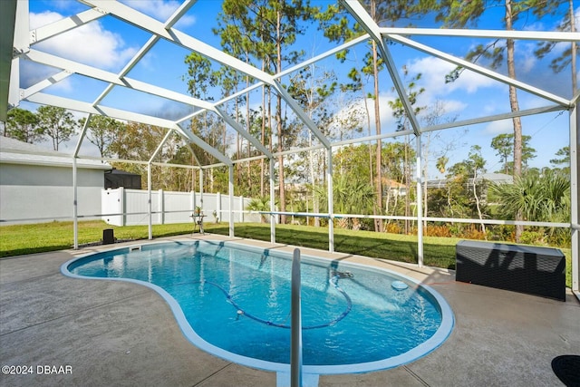 view of swimming pool featuring a yard, glass enclosure, and a patio area