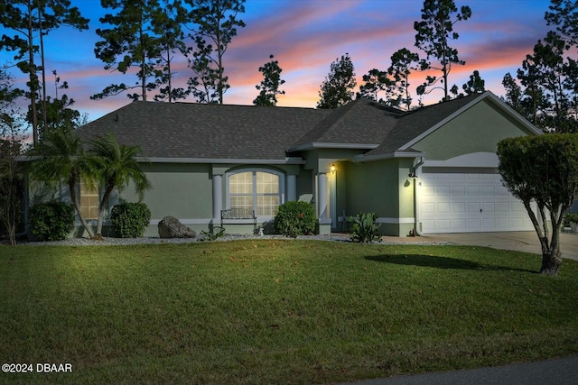 ranch-style home featuring a garage and a yard