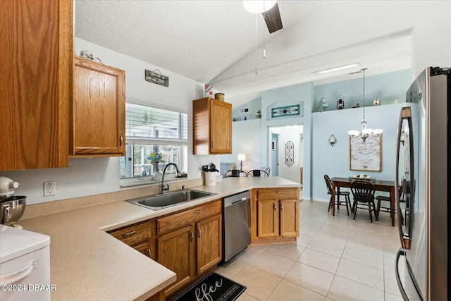 kitchen featuring pendant lighting, lofted ceiling, sink, kitchen peninsula, and stainless steel appliances