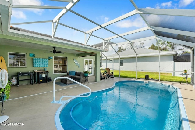 view of swimming pool featuring a lanai, ceiling fan, and a patio area