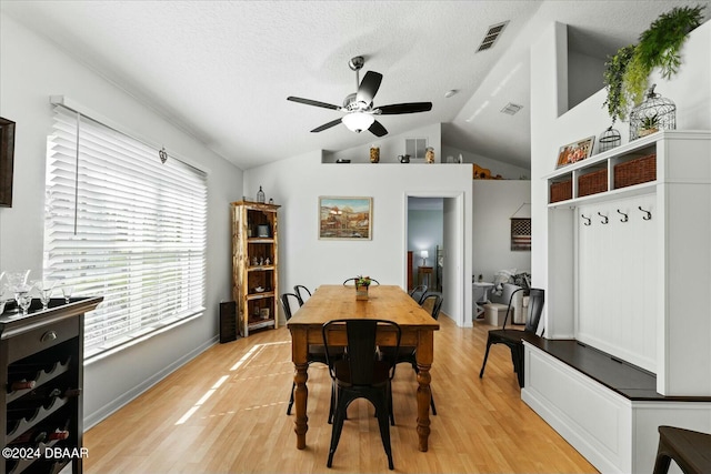 dining space featuring a textured ceiling, ceiling fan, lofted ceiling, and light wood-type flooring