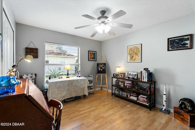 interior space with ceiling fan, a textured ceiling, and light wood-type flooring