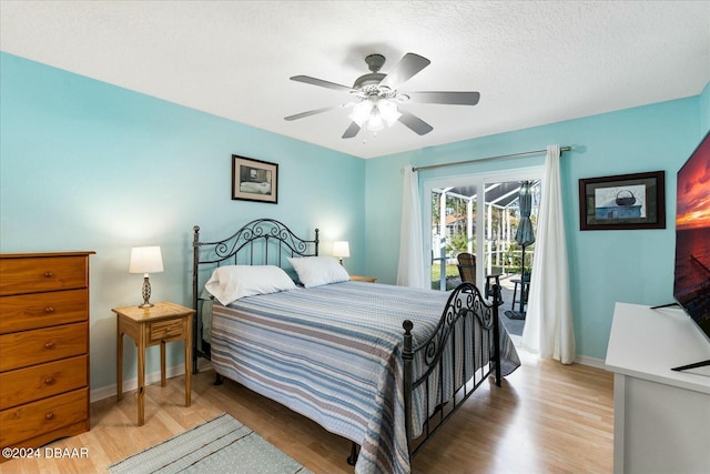 bedroom featuring access to outside, ceiling fan, wood-type flooring, and a textured ceiling