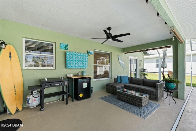 carpeted living room featuring ceiling fan and a textured ceiling