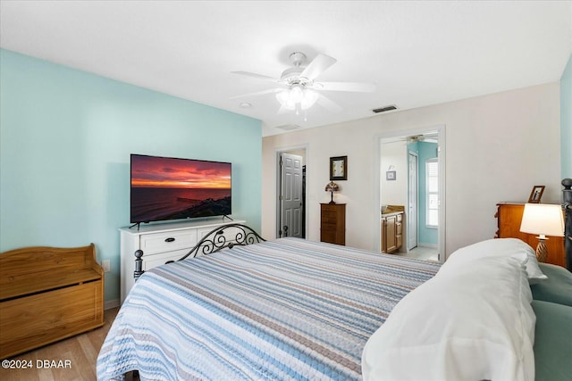 bedroom with light wood-type flooring, connected bathroom, and ceiling fan