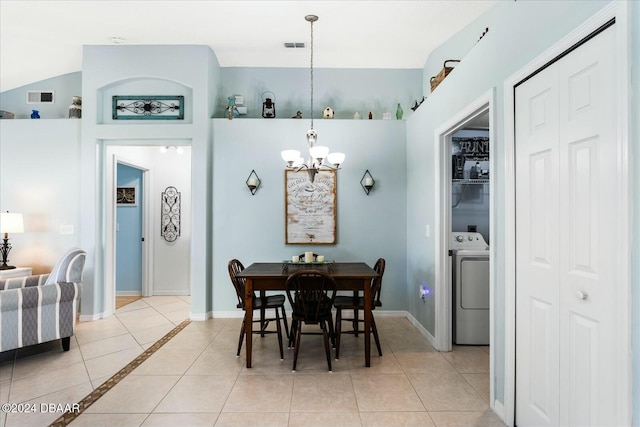 tiled dining room featuring washer / dryer, lofted ceiling, and a chandelier