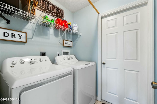 laundry room featuring washing machine and dryer and a textured ceiling