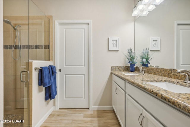 bathroom with walk in shower, vanity, and hardwood / wood-style flooring