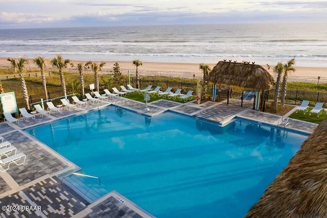 view of swimming pool with a view of the beach and a water view