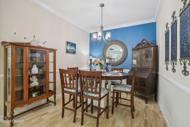 dining area featuring ornamental molding, light hardwood / wood-style floors, and an inviting chandelier