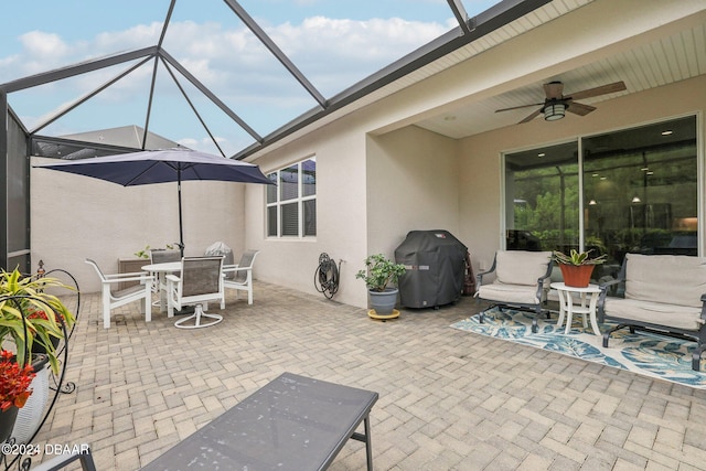 view of patio with glass enclosure, grilling area, and ceiling fan