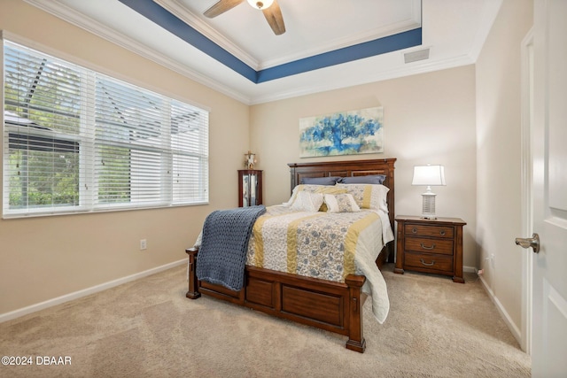 carpeted bedroom featuring ceiling fan, a raised ceiling, and ornamental molding