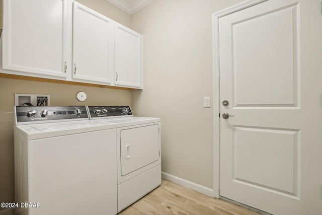 laundry room with ornamental molding, separate washer and dryer, light hardwood / wood-style floors, and cabinets