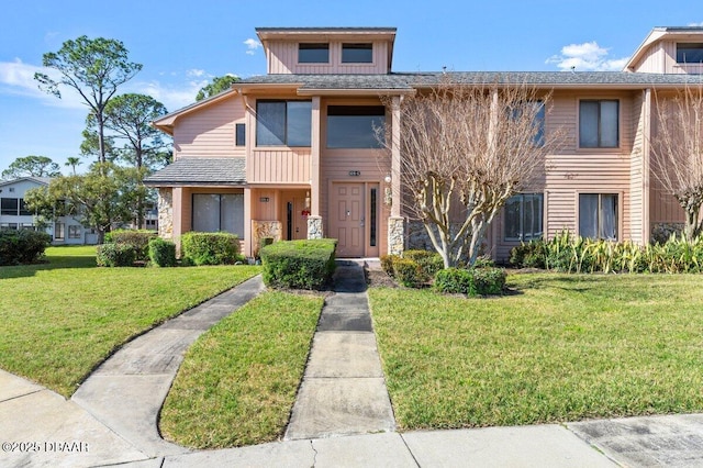 townhome / multi-family property featuring a front lawn