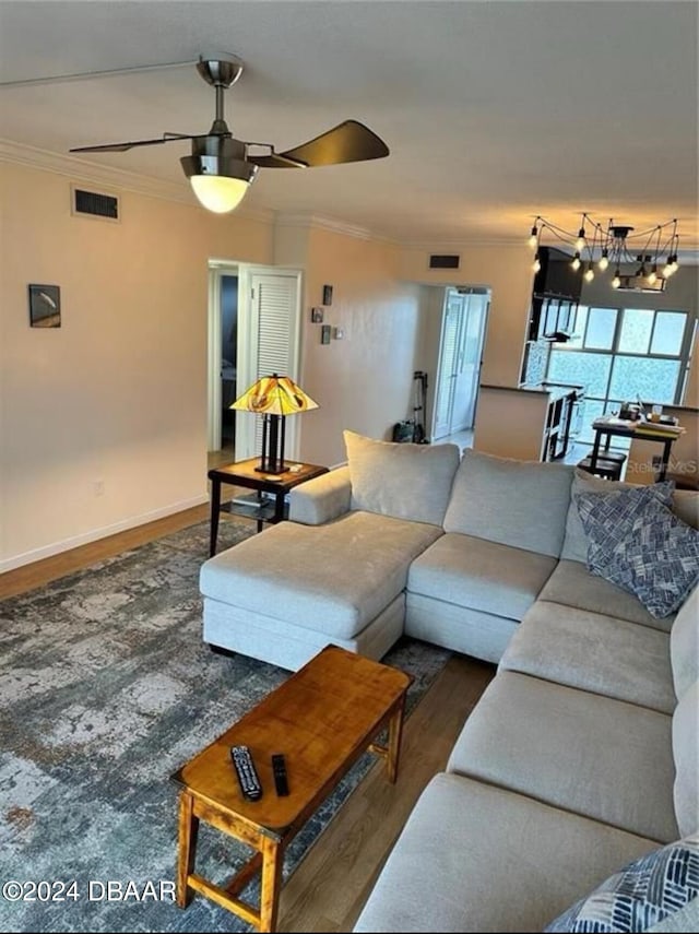 living room with ceiling fan, dark hardwood / wood-style flooring, and ornamental molding