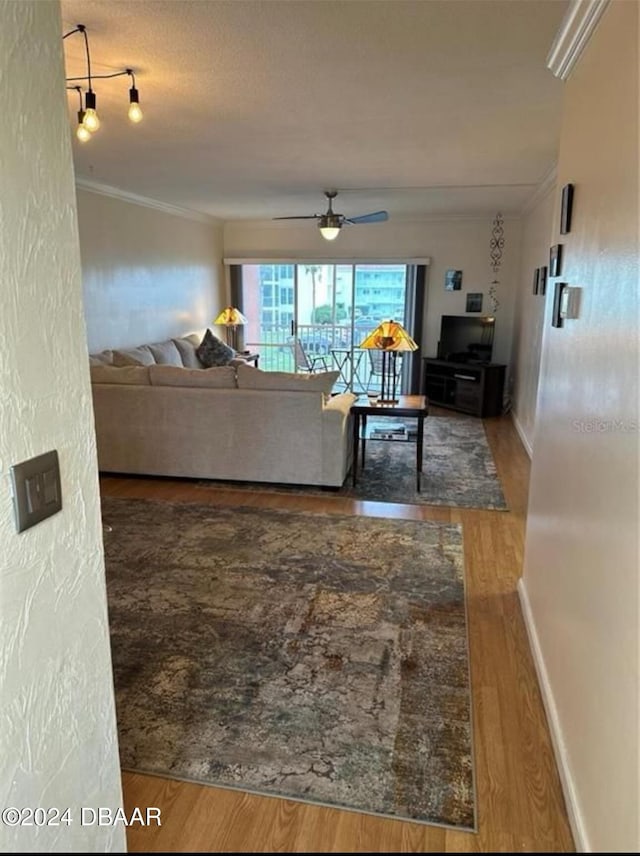 living room with wood-type flooring, ceiling fan, and ornamental molding