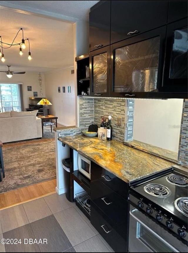 kitchen featuring stainless steel electric range, ceiling fan, light wood-type flooring, tasteful backsplash, and light stone counters