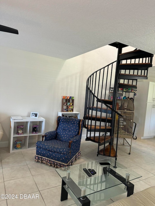 sitting room with tile patterned floors and a textured ceiling