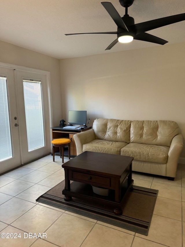 tiled living room featuring ceiling fan and french doors