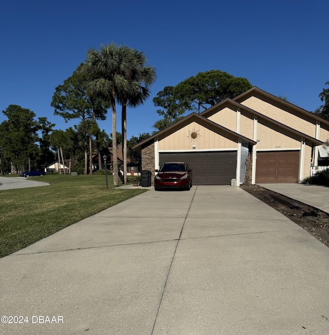 view of side of property featuring a garage and a lawn