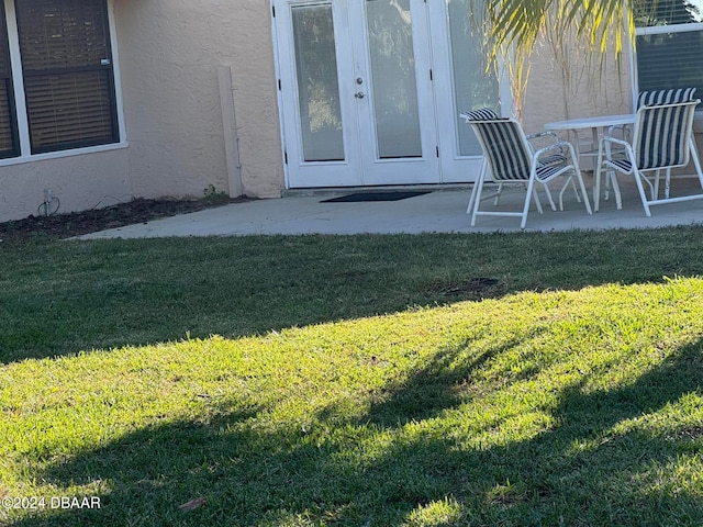 entrance to property with a lawn and a patio