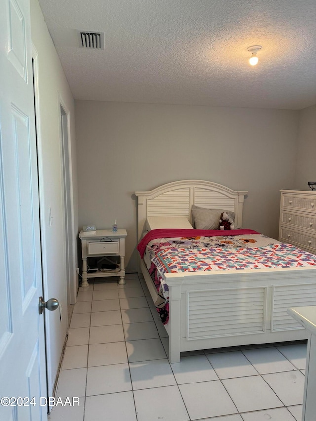 tiled bedroom with a textured ceiling