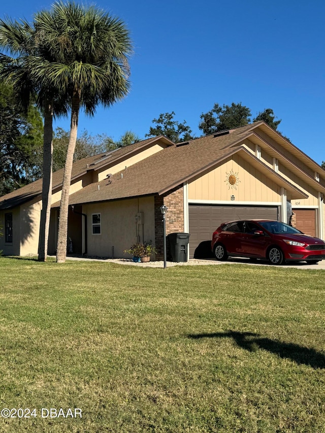 single story home featuring a garage and a front lawn