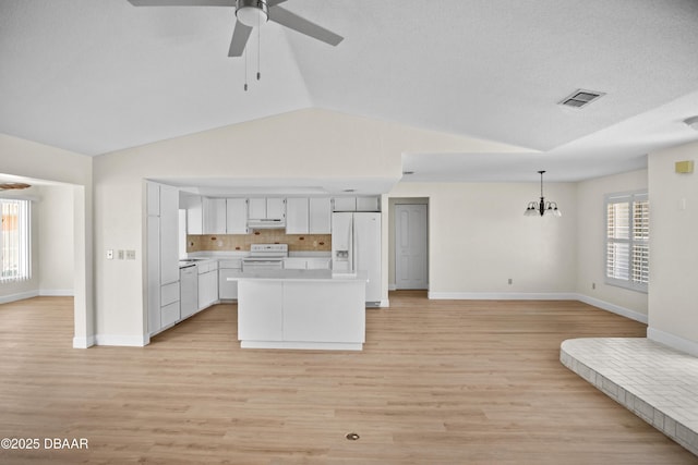 33 Sea Harbor Dr E, Ormond Beach, FL 32176 - kitchen featuring white appliances, under cabinet range hood, ceiling fan, lofted ceiling, and light countertops