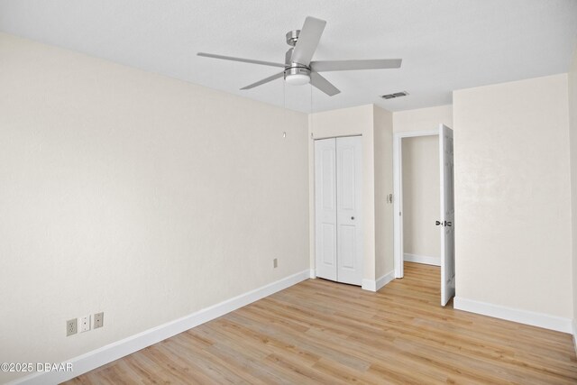 33 Sea Harbor Dr E, Ormond Beach, FL 32176 - unfurnished bedroom featuring light wood-type flooring, baseboards, a closet, and a ceiling fan