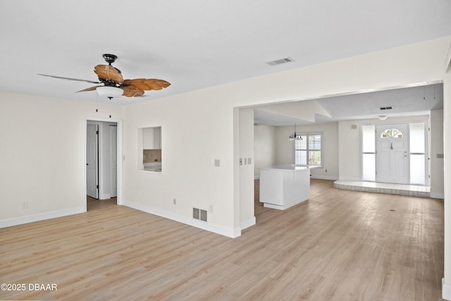 33 Sea Harbor Dr E, Ormond Beach, FL 32176 - unfurnished living room with baseboards, a ceiling fan, light wood-style floors, and a chandelier