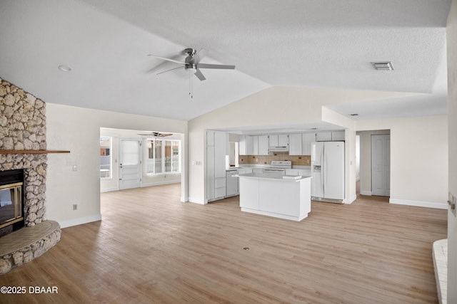 33 Sea Harbor Dr E, Ormond Beach, FL 32176 - unfurnished living room featuring a ceiling fan, a stone fireplace, baseboards, light wood finished floors, and high vaulted ceiling