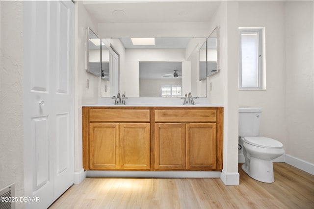 33 Sea Harbor Dr E, Ormond Beach, FL 32176 - full bath featuring wood finished floors, toilet, double vanity, ceiling fan, and baseboards