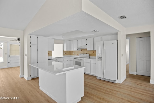 33 Sea Harbor Dr E, Ormond Beach, FL 32176 - kitchen featuring white appliances, under cabinet range hood, light wood finished floors, and white cabinets