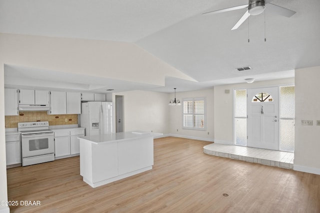 33 Sea Harbor Dr E, Ormond Beach, FL 32176 - kitchen with white appliances, lofted ceiling, light countertops, under cabinet range hood, and a chandelier