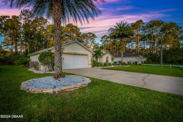 ranch-style home with a garage and a yard