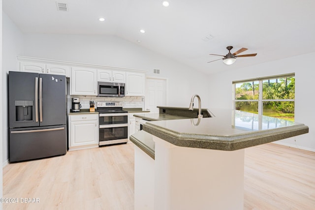 38 Rickenbacker Dr, Palm Coast, FL 32164 - kitchen featuring stainless steel appliances, light wood-style floors, vaulted ceiling, white cabinetry, and recessed lighting
